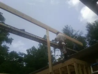 Carpenter setting a ridge beam over a new addition frame — Ice Dam Removal by Roofing Brothers in Wilkes Barre