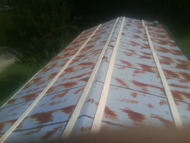 Rusted metal roof panels with new wood purlins before replacement — Storm Damage Roof Repair in Wilkes Barre by Roofing Brothers