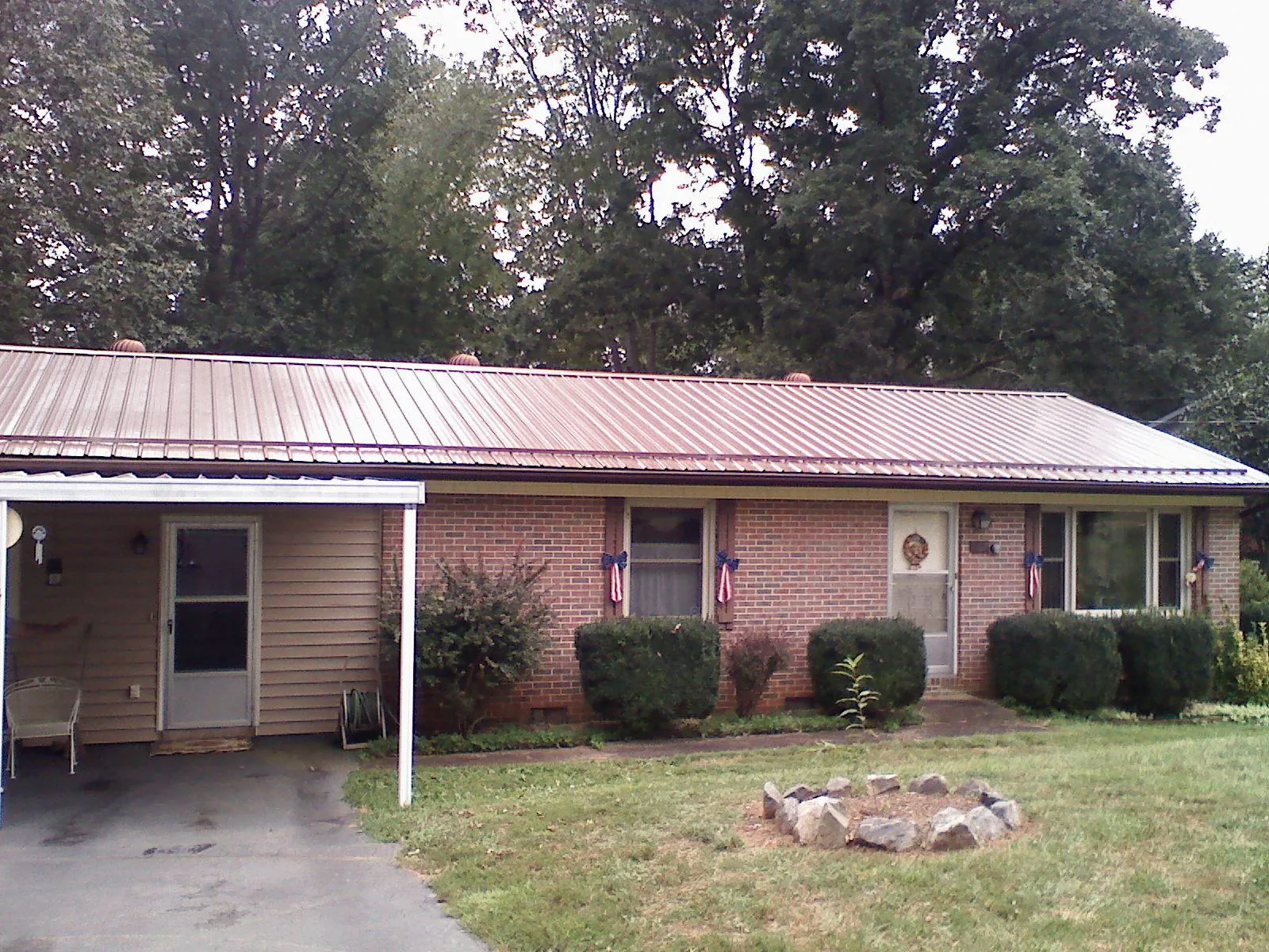 Bronze metal roof and carport on a brick ranch home — Roof Repair work by our crew in Wilkes Barre